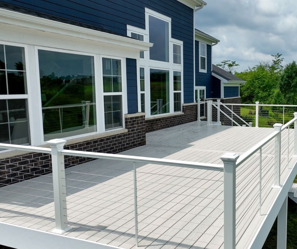 White Deck With Blue House And Cable Railing